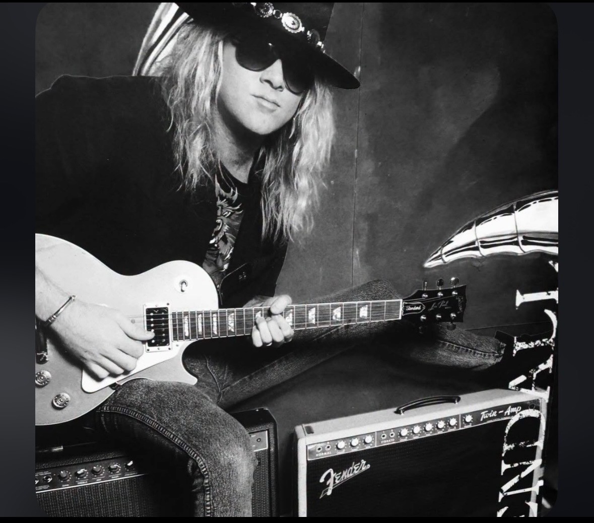 Young Mark Kendall seated with a Les Paul in front of a Fender Twin amp