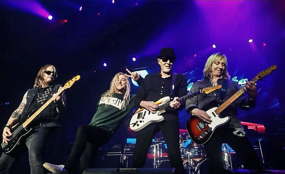 Great White performing together beneath purple stage lights