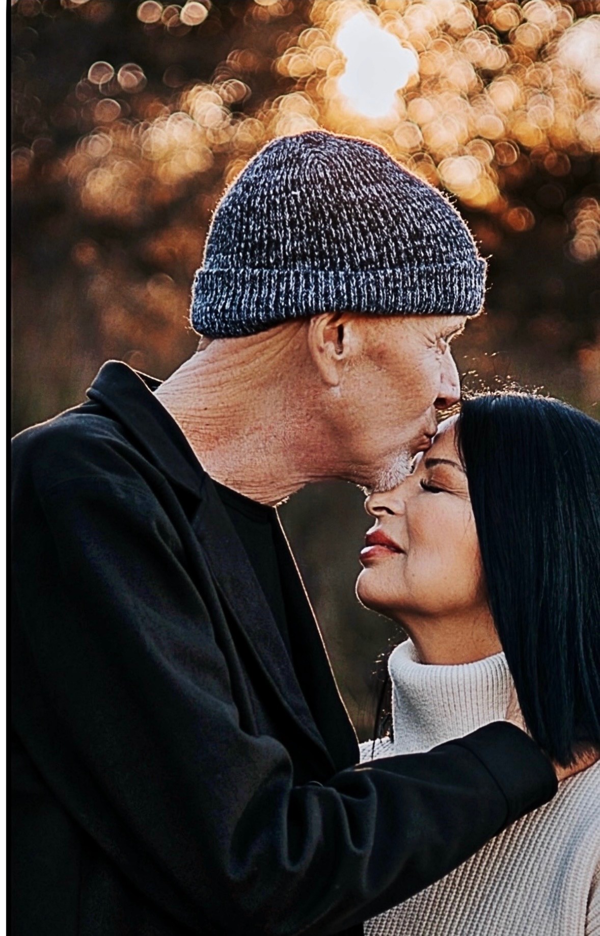 Mark Kendall kissing his wife Bridget on the forehead outdoors
